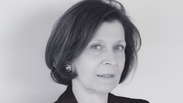 Black and white photo of a woman with short hair, wearing earrings.