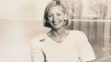 Smiling woman with short hair in a light blouse, monochrome photograph.