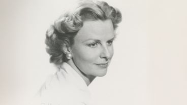 Black and white portrait of a woman with styled hair and pearl earrings.