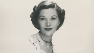 Black and white portrait of a woman with wavy hair and a necklace.