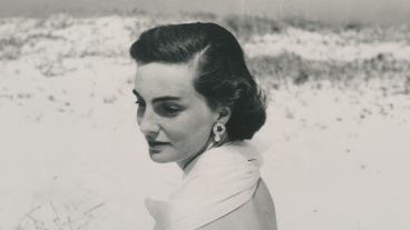 Woman with short hair and earrings on a snowy landscape, looking contemplative.