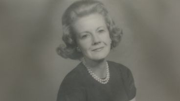 Black and white portrait of a woman with styled hair and a pearl necklace.