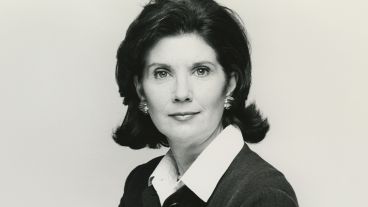 Black and white portrait of a woman with dark hair wearing a suit.