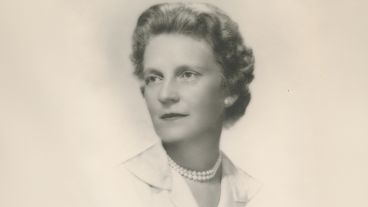 Black and white portrait of a woman in a pearl necklace, looking to the side.