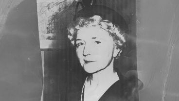 Black and white photo of an older woman wearing a hat and pearls.