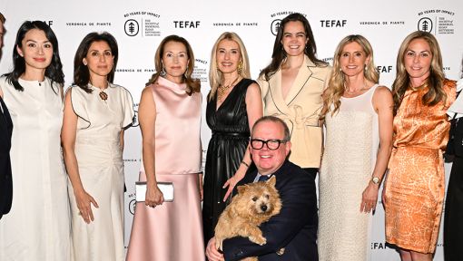Nine people standing, and one person kneeling and holding a small brown dog, in front of a Society of MSK background that also includes the TEFAF and Veronica De Piante Logos.