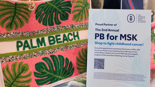 A sign with information about PB for MSK next to a Palm Beach tote bag with tropical leaf design .