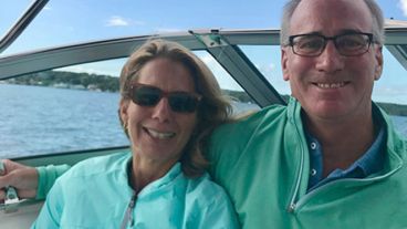 MSK Giving donor Samantha and her late husband, Rich, seated on a boat. Rich has his arm around Samantha, and they are both smiling.