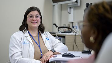 An MSK nurse speaks with a patient in an exam room.