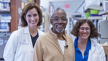From left to right: MSK physician-scientist Dr. Adrienne Boire, MSK patient Carlos, and MSK computational biologist Dr. Dana Pe’er standing in an MSK lab. 