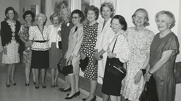 11 members of The Society of MSK stand in a hallway. 